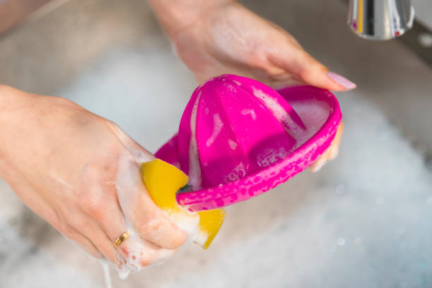 istock Woman washing a plastic squeezer over the sink 1204646538