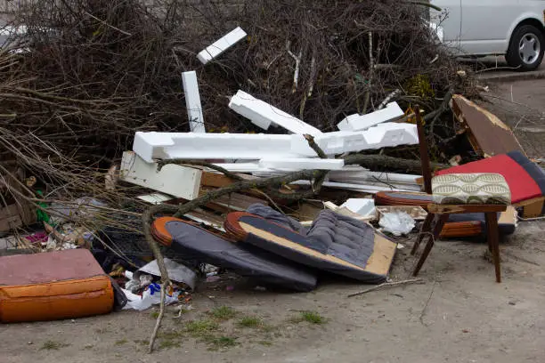 A pile of household furnishings, damaged by Hurricane, placed curbside, awaiting trash removal.