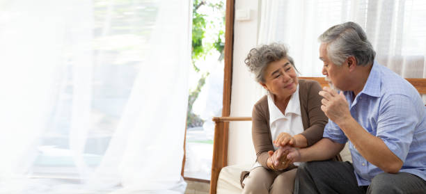 asiatische senior rentner paar hält hände und kümmern sich zusammen zu hause, alzheimer-krankheit oder leiden mit demenz-konzept - senior adult depression dementia alzheimers disease stock-fotos und bilder