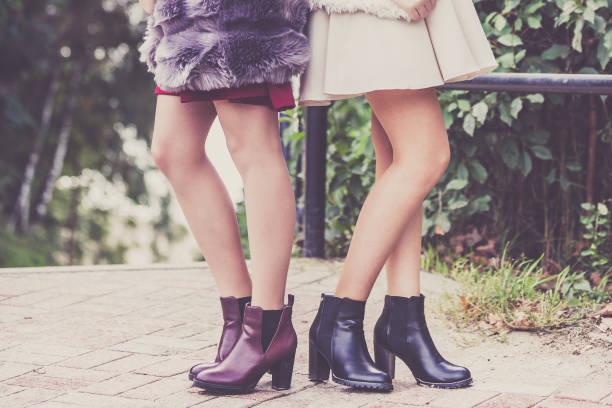 istock Two women presenting shoes outdoor 1204649138