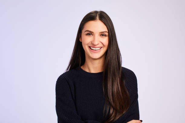 istock Young woman wearing a sweater and laughing on a colored background 1204649499