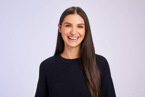 istock Laughing young brunette woman standing against a colored background 1204650235