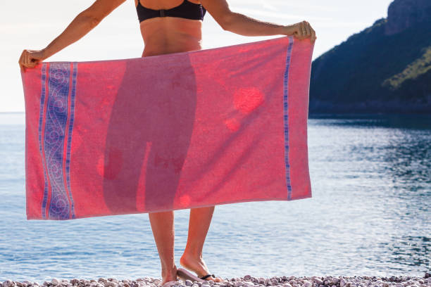 istock Woman on beach covering hips with towel 1204651276