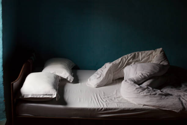 istock Bed with white blanket, blue walls in village house 1204659950