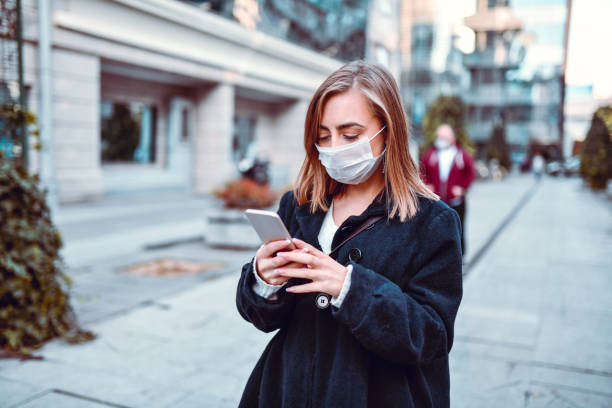 istock Female Finding Her Way On GPS While Wearing Anti Air Pollution Mask 1204660134