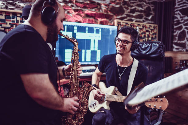istock Sax Player Ang Guitarist Working On New Song In Studio 1204663319