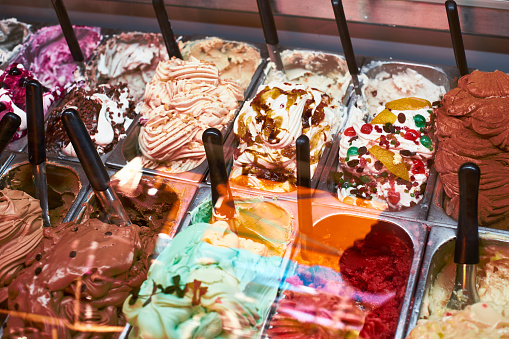 Assortment of Italian artisan ice cream flavors behind the shop