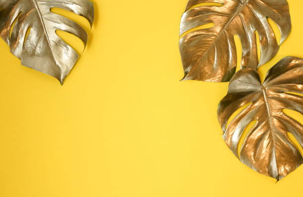 istock Gold leaves plant tropical monstera  pattern on a yellow background. top view.abstract. 1204665238
