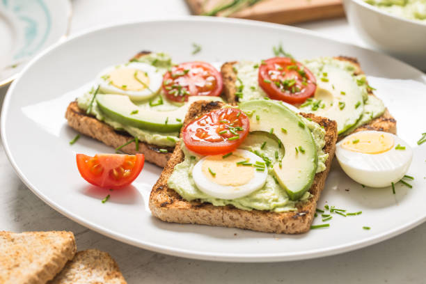 istock Healthy breakfast from toasts with avocado spread guacamole egg tomato and chives. 1204666400