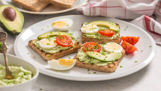 istock Healthy breakfast from toasts with avocado spread guacamole egg tomato and chives. 1204666405