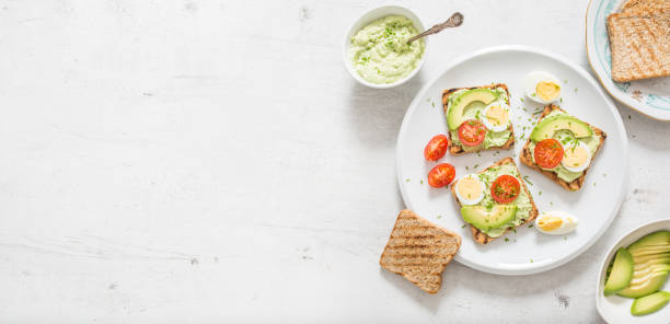 istock Healthy breakfast from toasts with avocado spread guacamole egg tomato and chives. 1204666425