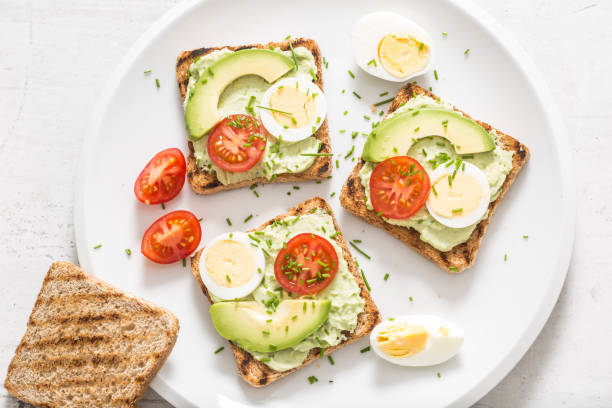 istock Healthy breakfast from toasts with avocado spread guacamole egg tomato and chives. 1204666427