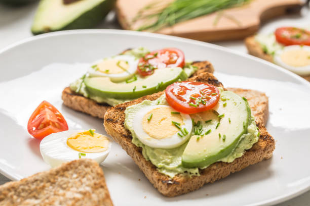 istock Healthy breakfast from toasts with avocado spread guacamole egg tomato and chives. 1204666429