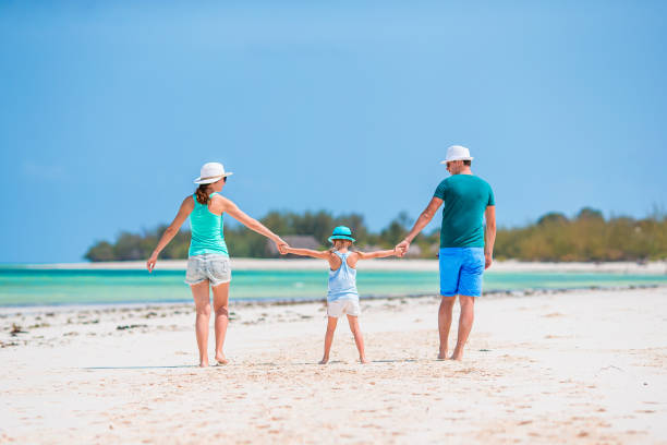 istock Young family on white beach during summer vacation 1204667918