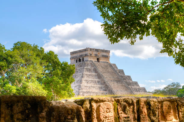 piramide di chichen itza di kuklukan con tzompantli o parete di teschi in primo piano - tzompantli foto e immagini stock