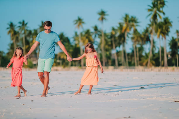 istock Father and little kids on the beach 1204669048