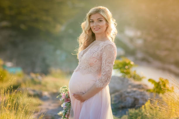 自然の中で妊婦。屋外で白い長いドレスで美しい女性の未来の母親 - bride women standing beauty in nature ストックフォトと画像