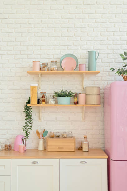 istock Kitchen shelves, wooden surface and pink fridge on white background. White kitchen interior counter top 1204670971
