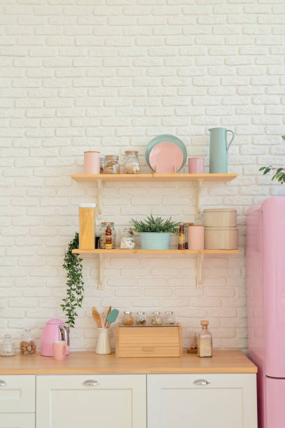 istock Kitchen shelves, wooden surface and pink fridge on white background. White kitchen interior counter top 1204670996