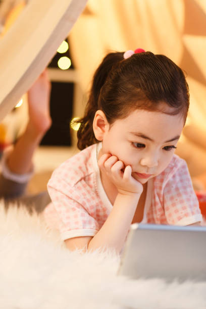 istock Cute little girl looking at Tablet PC 1204671408