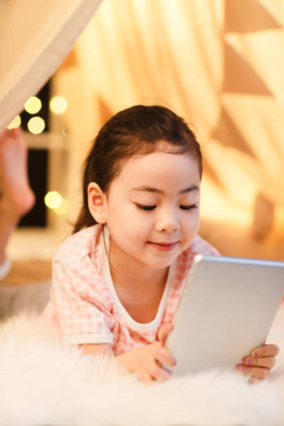 istock Cute little girl looking at Tablet PC 1204671433