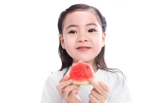 istock The cute little girl eats watermelon 1204671479