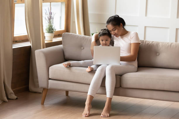 istock Young ethnic mom and little daughter use computer together 1204673180