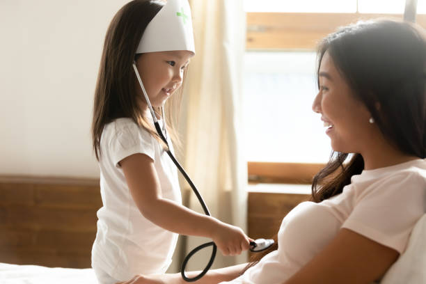 docteur asiatique de jeu de petite fille avec la jeune maman - patient hospital doctor nurse photos et images de collection