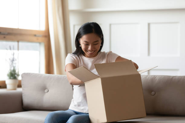 istock Excited asian girl unpack cardboard parcel online order 1204673276