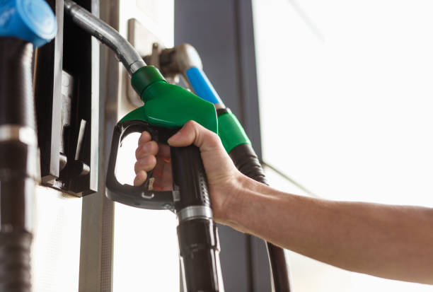 istock Crop hand taking green fuel dispenser 1204675430