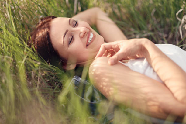 istock Joyful modern woman relaxing on meadow grass 1204675555
