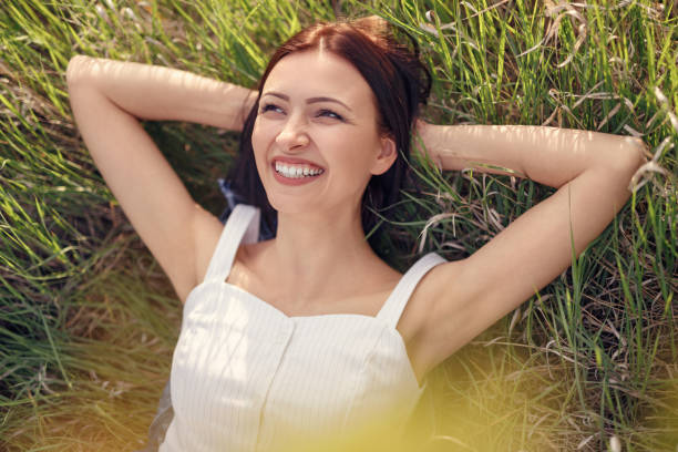 istock Happy woman enjoying sunny day on grass 1204675566