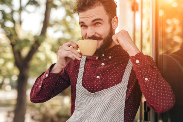 istock Glad waiter drinking outside cafe 1204675630