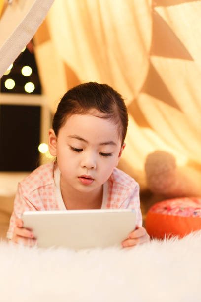 istock Cute little girl looking at Tablet PC 1204675712