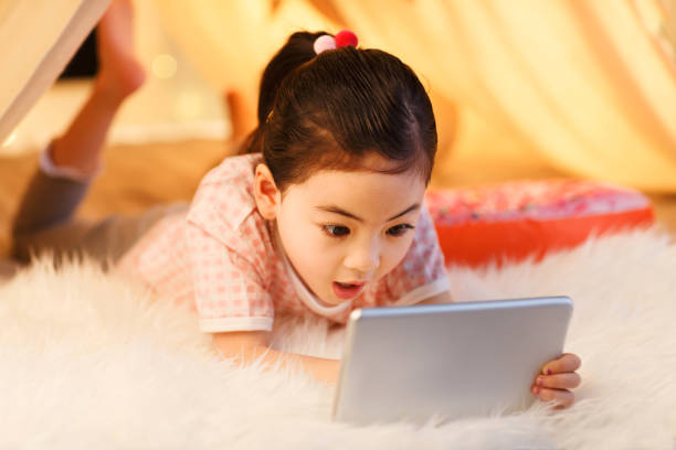 istock Cute little girl looking at Tablet PC 1204675774