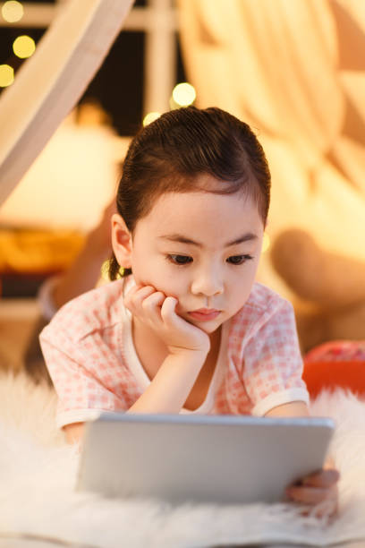 istock Cute little girl looking at Tablet PC 1204675813