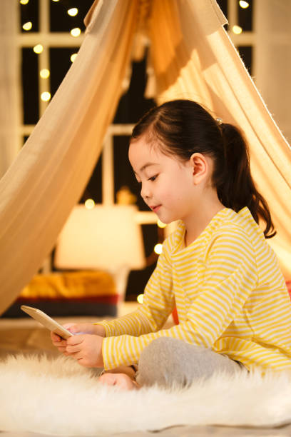 istock Cute little girl looking at Tablet PC 1204675856