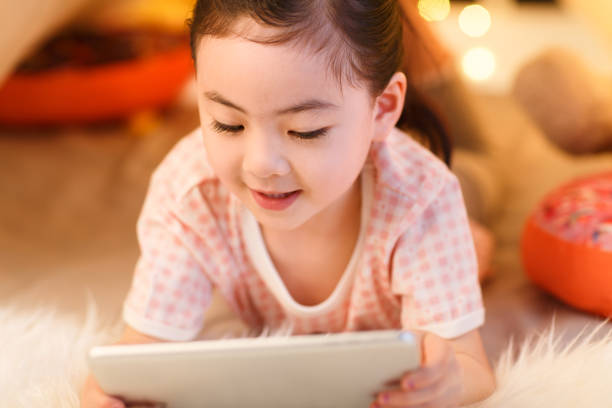istock Cute little girl looking at Tablet PC 1204675867