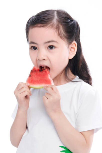 istock The cute little girl eats watermelon 1204675993