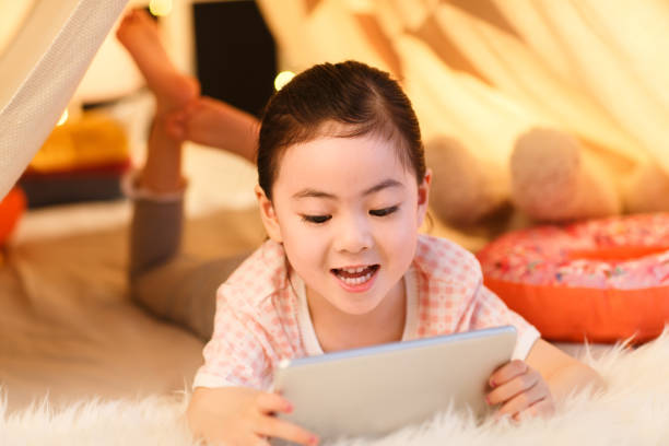 istock Cute little girl looking at Tablet PC 1204676633