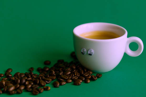 green coffee cup with grains and raffia cloth background