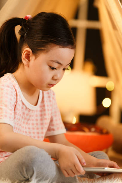 istock Cute little girl looking at Tablet PC 1204676793
