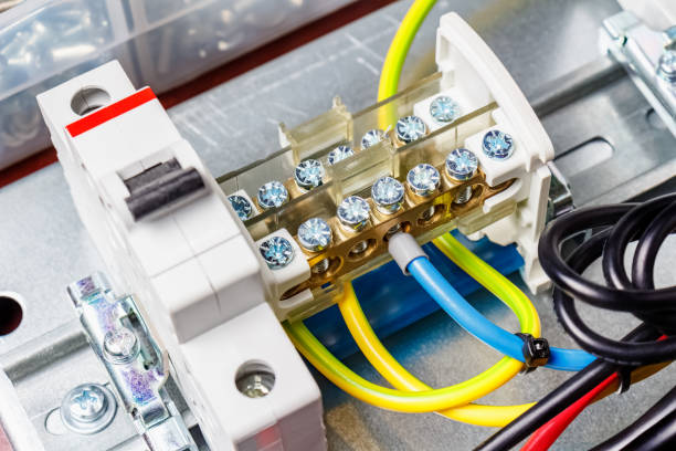 istock Wire terminal and automatic circuit breaker with connected colored wires installed on electrical panel. Close-up view 1204678085