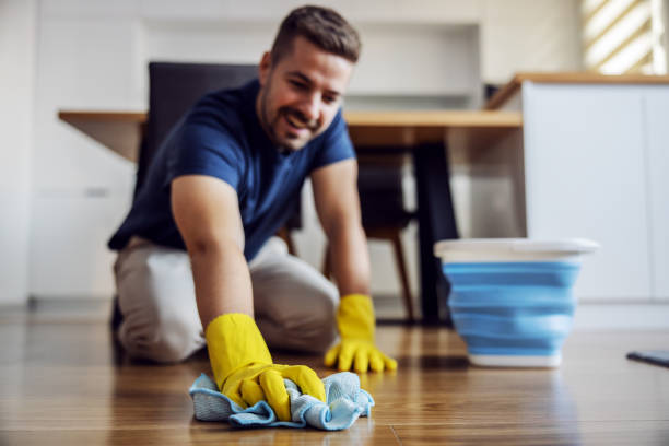 mann wachsen parkett zu hause. selektiver fokus auf hand mit tuch. gummihandschuhe an den händen. innenbereich. - lappen reinigungsgeräte stock-fotos und bilder