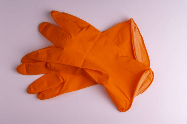 istock Orange latex gloves for household use on a white background. 1204682130