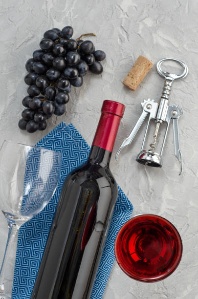 istock Bottle, wine glass with wine, grapes and corkscrew on gray background. 1204682642