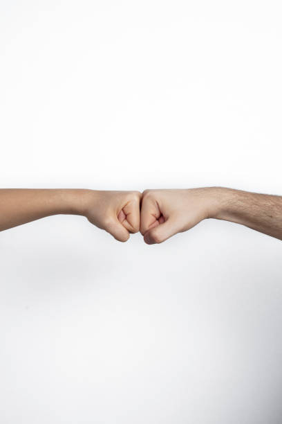 istock Man and woman hitting fists over white background 1204683786