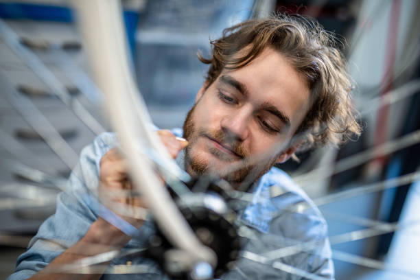 istock Young mechanic examining a bent bicycle wheel. 1204683898