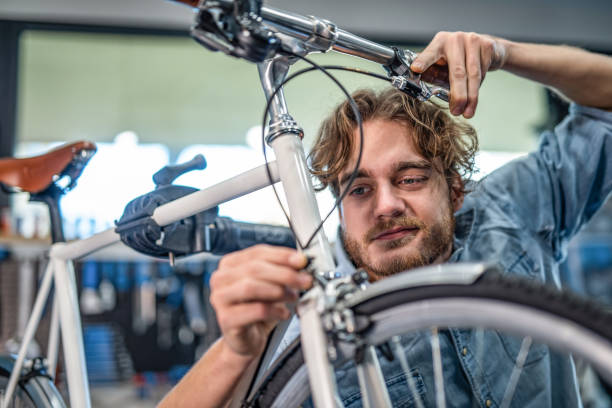 istock Mechanic repairing bicycle breaks in workshop 1204684029