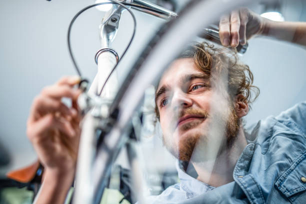 istock Mechanic repairing bicycle breaks in workshop 1204684186